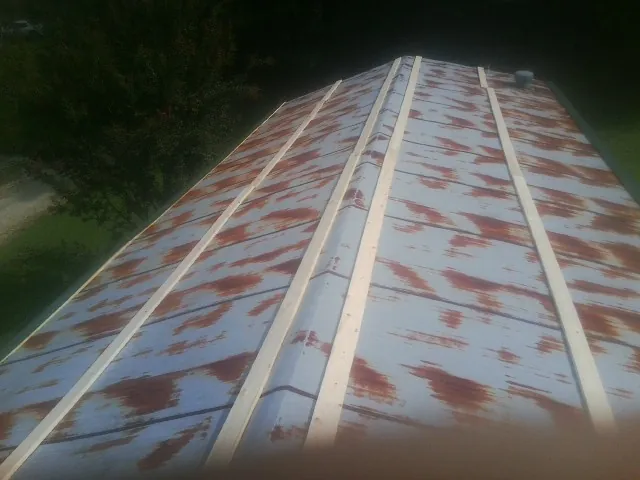 Rusted metal roof panels with new wood purlins before replacement — Storm Damage Roof Repair in Guffey by Roofing Brothers