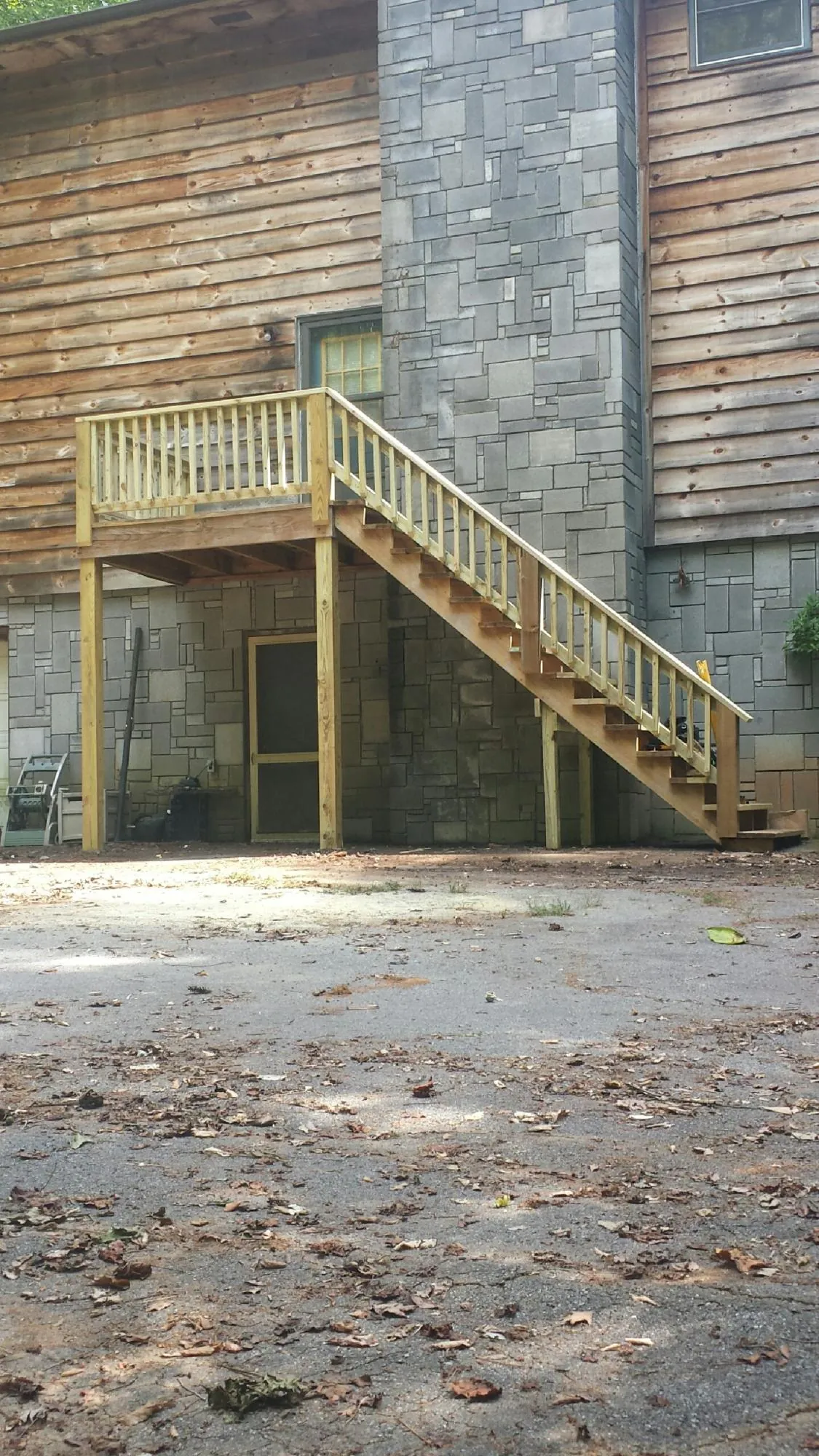 New pressure treated deck and stair landing on a log home in Guffey