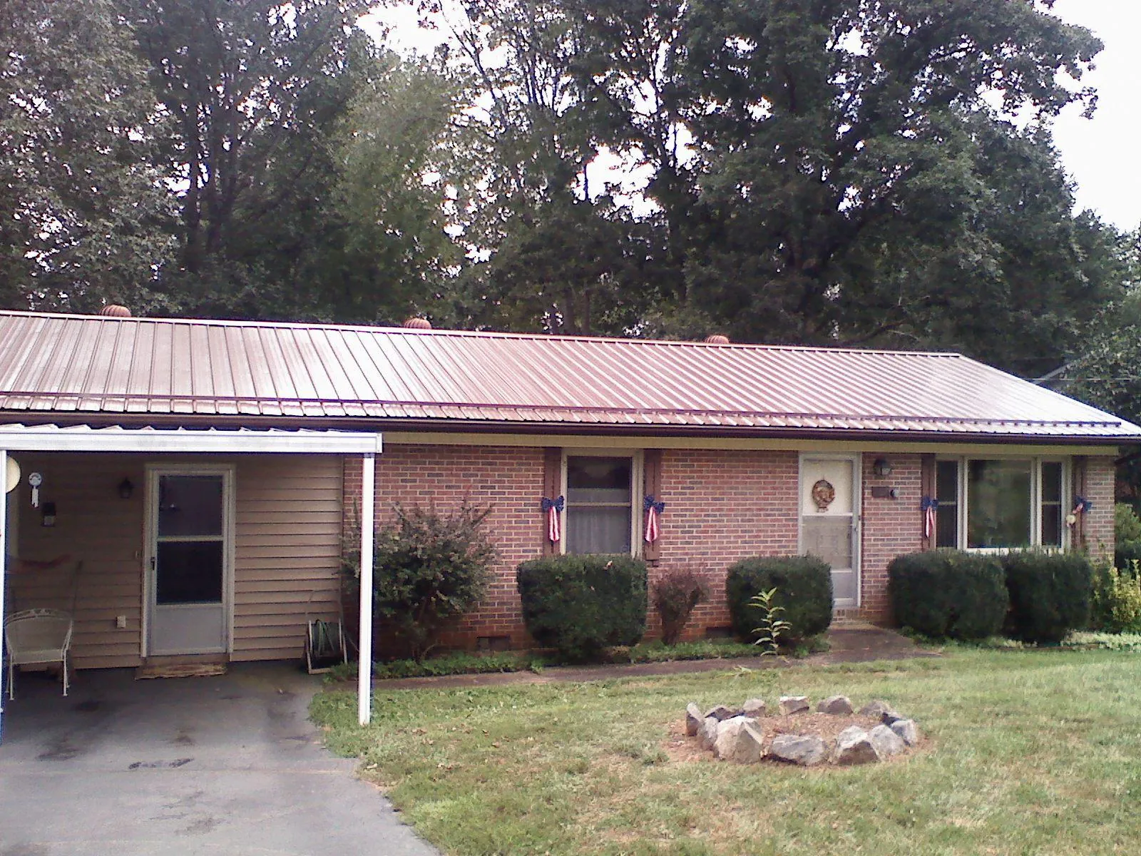 Bronze metal roof and carport on a brick ranch home — Roof Repair work by our crew in Guffey